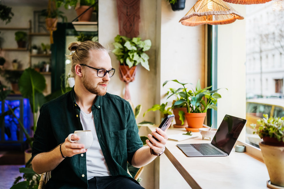 Student Using Smartphone While Drinking Coffee